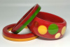 Jessie Fowler chunky crimson red bakelite bangle with several sizes and colors of bakelite dots